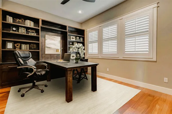 a view of a workspace with furniture and a window