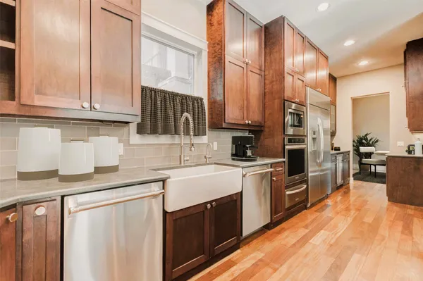a kitchen with stainless steel appliances granite countertop a stove a sink and a refrigerator