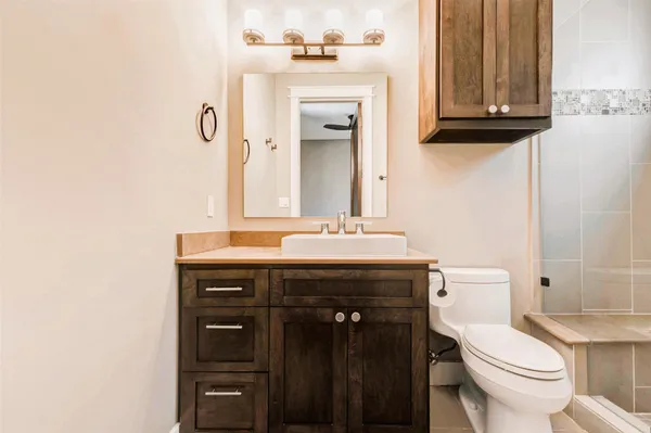 a bathroom with a sink a toilet and mirror