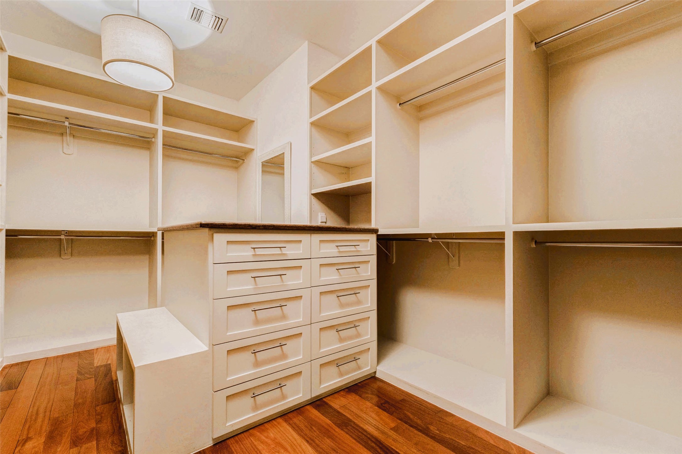 2219 Columbia Street Houston, TX 77008 - Photo 23 of 45 Walk in closet with floor-to-ceiling built-in shelving and a central drawer island for optimal organization. Brazilian Teak Hardwood Floors, modern hardware, and a designer pendant light,