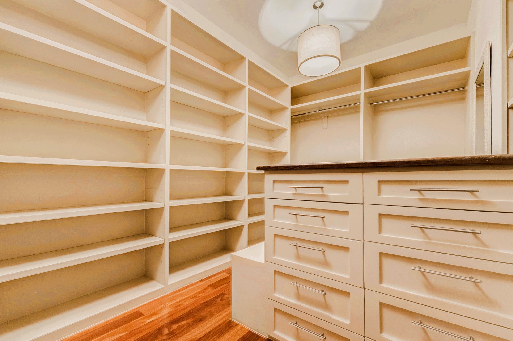 2219 Columbia Street Houston, TX 77008 - Photo 25 of 45 Walk in closet with floor-to-ceiling built-in shelving and a central drawer island for optimal organization. Brazilian Teak Hardwood Floors, modern hardware, and a designer pendant light,