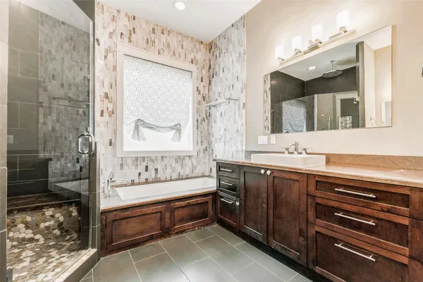 a spacious bathroom with a bathtub shower sink and mirror