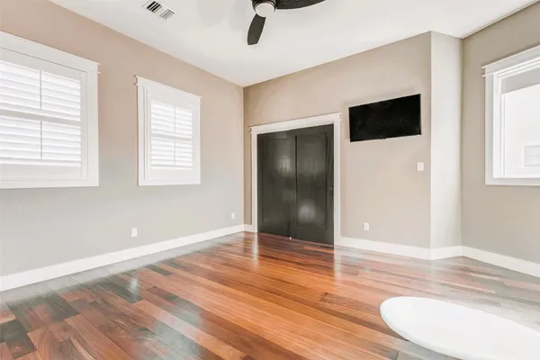 a view of a livingroom with wooden floor and a ceiling fan