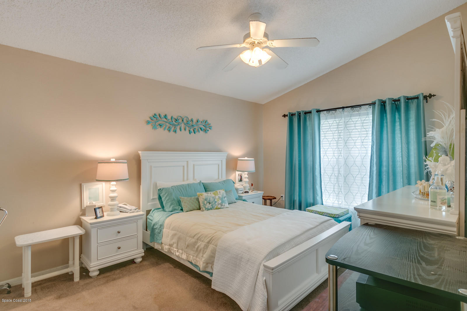 2009 Redwood Circle Palm Bay, FL 32905 - Photo 20 of 32 a spacious bedroom with a bed and a chandelier