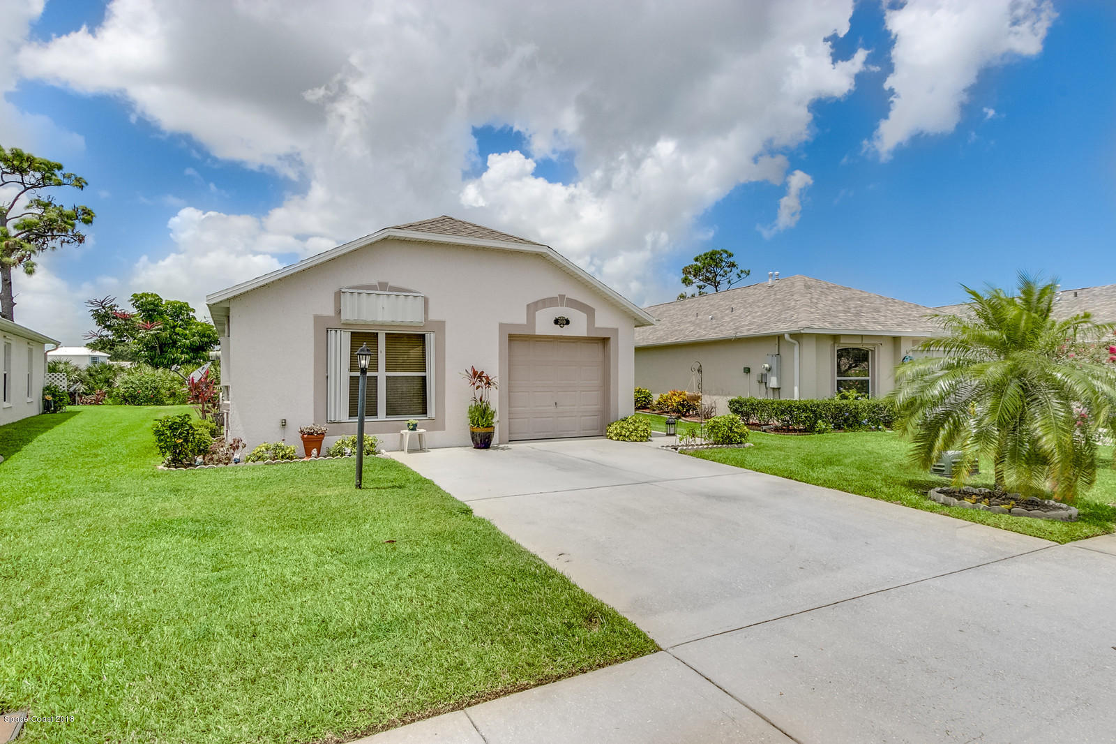 2009 Redwood Circle Palm Bay, FL 32905 - Photo 3 of 32 a front view of a house with a garden and yard
