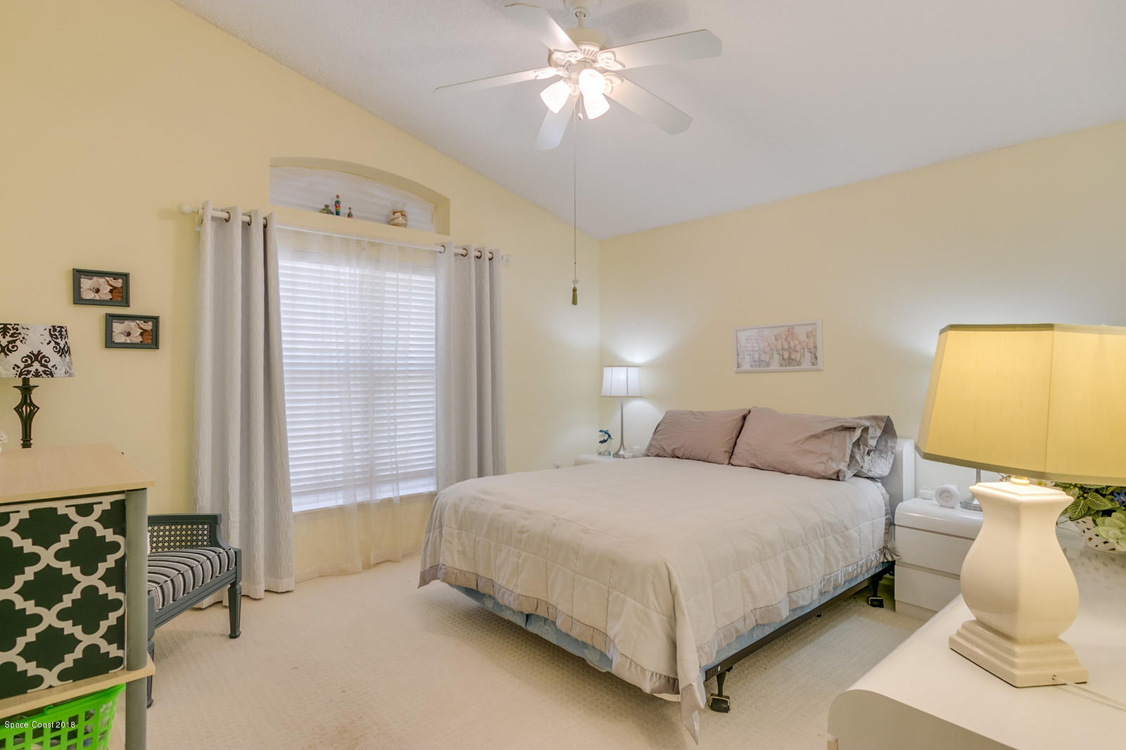 2009 Redwood Circle Palm Bay, FL 32905 - Photo 23 of 32 a bedroom with a bed and a chandelier