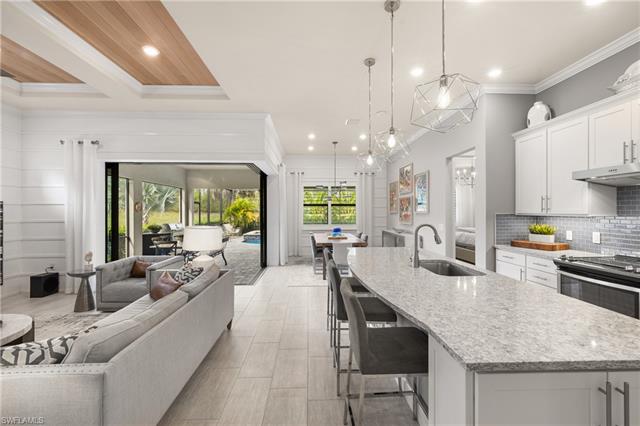 a large kitchen with kitchen island a large center island attached withe living room