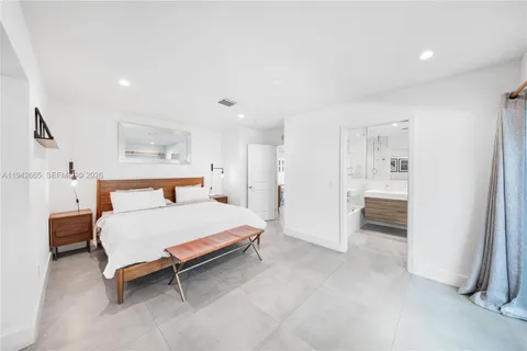 a spacious bedroom with a bed and a view of bathroom