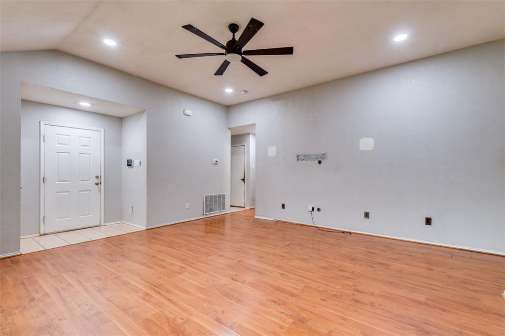 107 Bowie Street Forney, TX 75126 - Photo 3 of 25 an empty room with ceiling fan and wooden floor