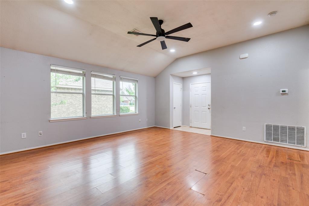 107 Bowie Street Forney, TX 75126 - Photo 4 of 25 an empty room with wooden floor fan and windows