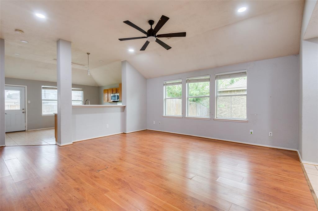107 Bowie Street Forney, TX 75126 - Photo 5 of 25 a view of an empty room with a window and wooden floor