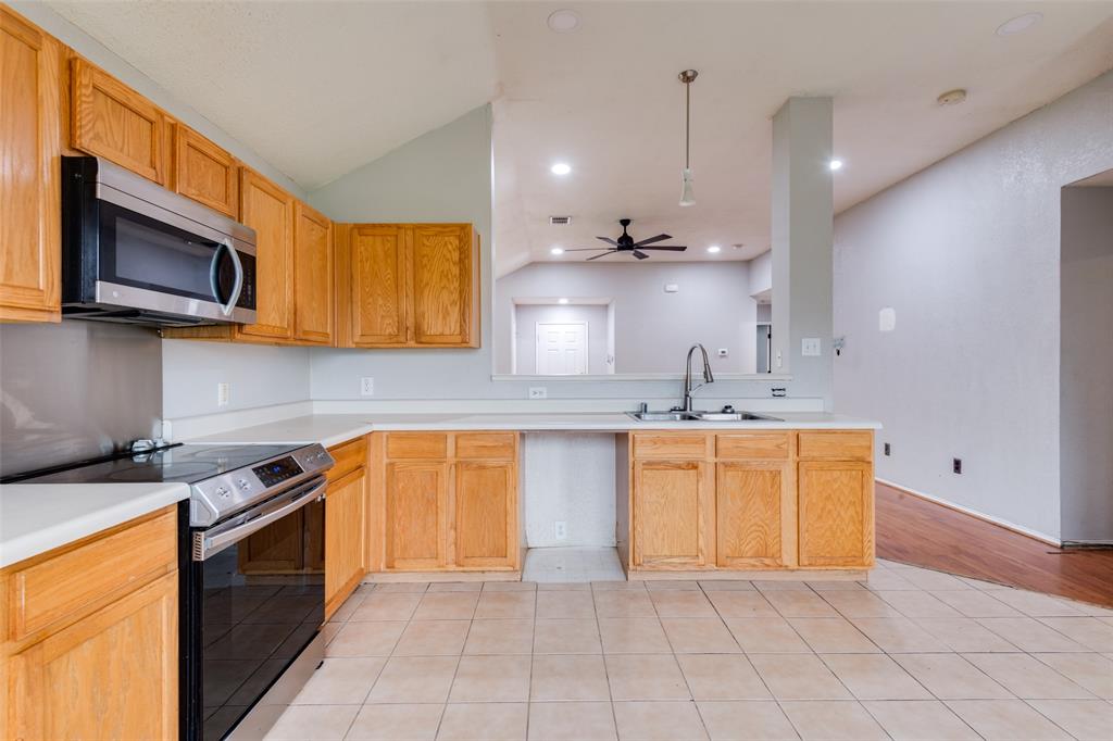 107 Bowie Street Forney, TX 75126 - Photo 7 of 25 a kitchen with stainless steel appliances granite countertop a sink a stove a microwave and cabinets