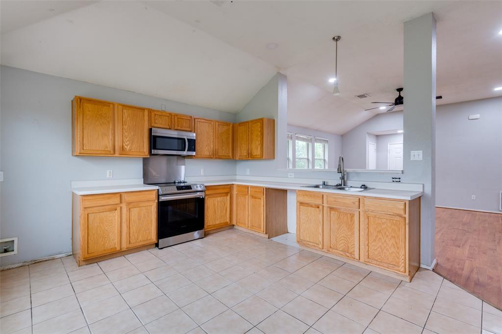 107 Bowie Street Forney, TX 75126 - Photo 8 of 25 a large kitchen with stainless steel appliances granite countertop a stove sink and cabinets