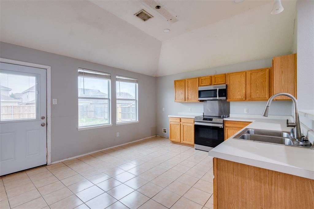 107 Bowie Street Forney, TX 75126 - Photo 9 of 25 a kitchen with stainless steel appliances a stove sink and cabinets
