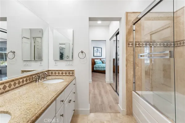 a spacious bathroom with a granite countertop tub sink and mirror