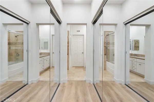 a view of a hallway with wooden floor and glass door