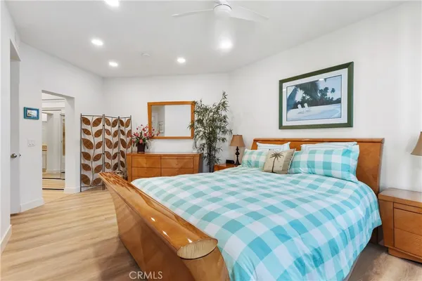 a bedroom with a large bed and a wooden floor