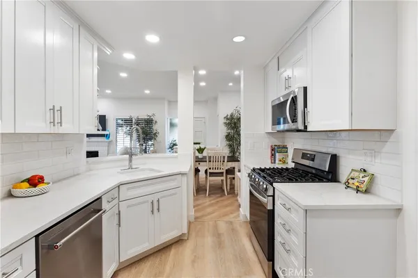 a kitchen with stainless steel appliances granite countertop a sink stove and cabinets