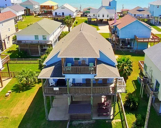 an aerial view of a house with swimming pool and large trees