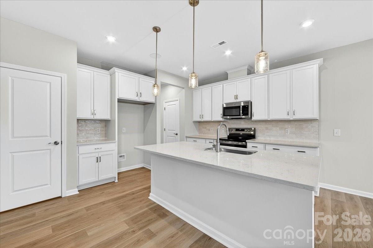 512 Webster Lane Cramerton, NC 28032 - Photo 4 of 28 a large kitchen with cabinets wooden floor and stainless steel appliances