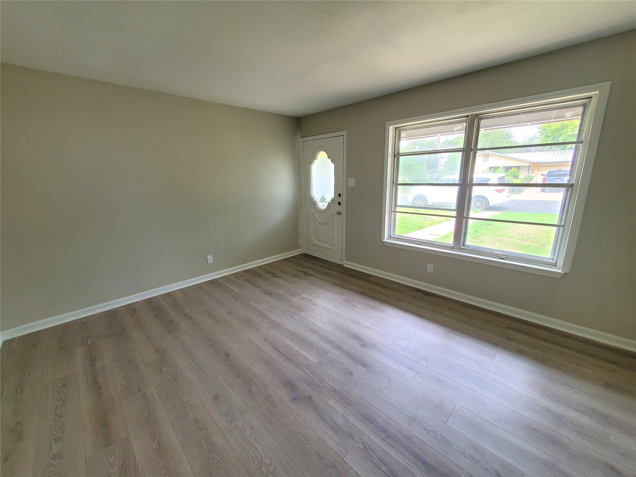 8907 Shepard Drive Austin, TX 78753 - Photo 3 of 14 an empty room with wooden floor and windows