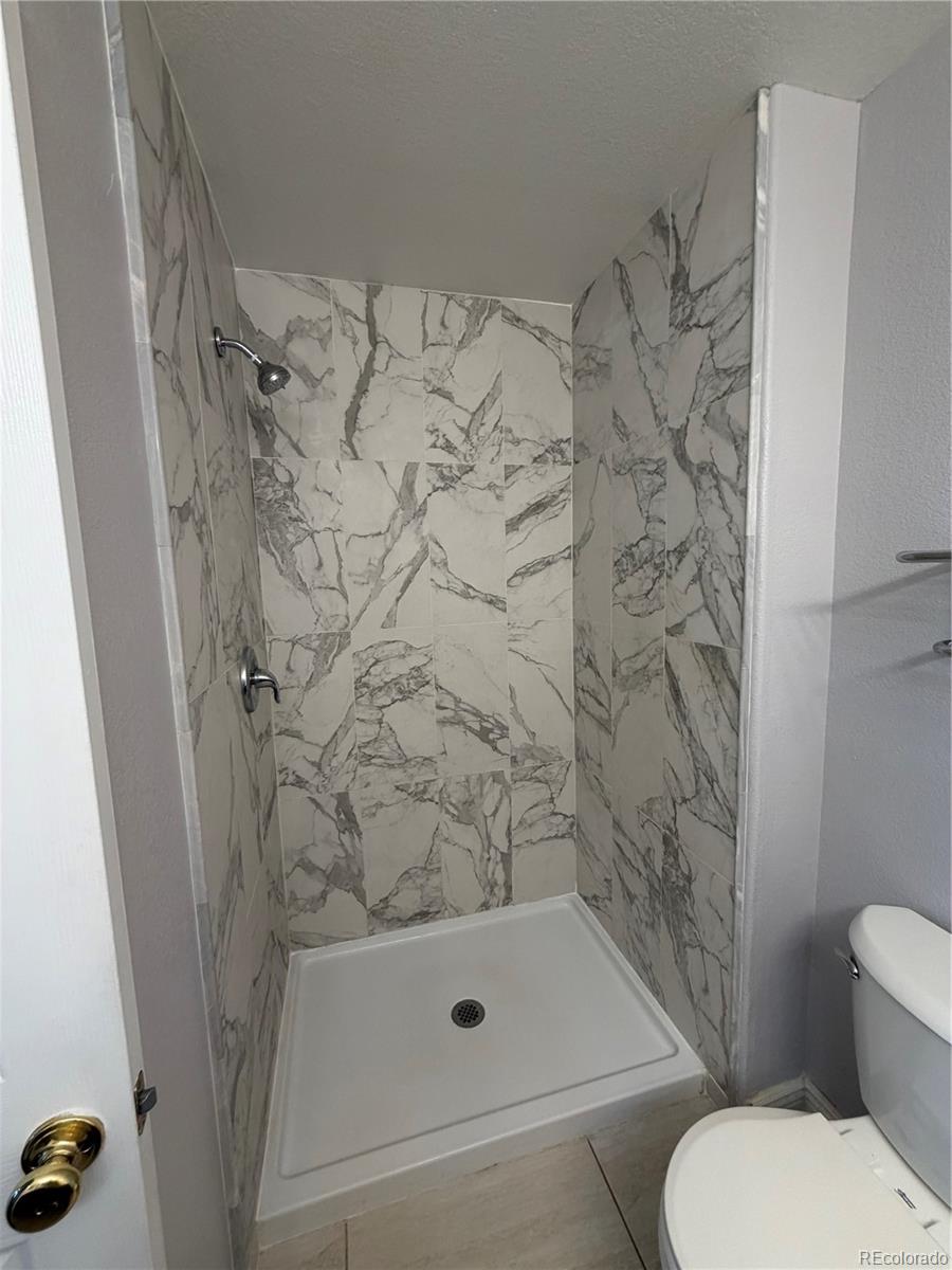 6369 Cole Lane Arvada, CO 80004 - Photo 3 of 21 a bathroom with a shower and a toilet