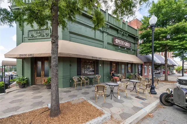 a front view of a house with street and trees