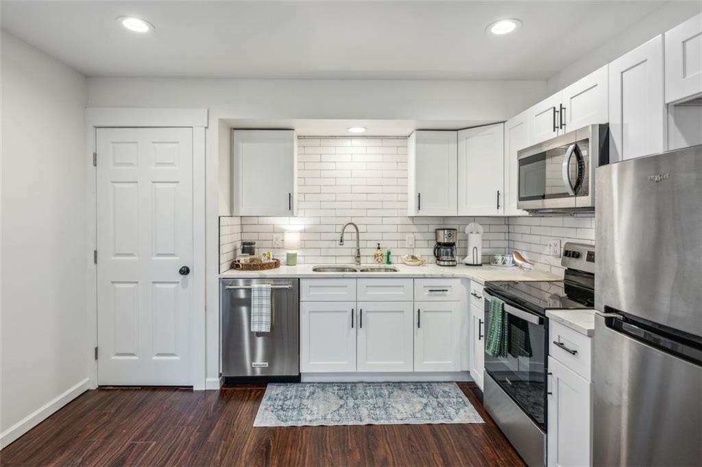 21 Willow Woods Road Social Circle, GA 30025 - Photo 10 of 49 a kitchen with stainless steel appliances a sink cabinets and wooden floor