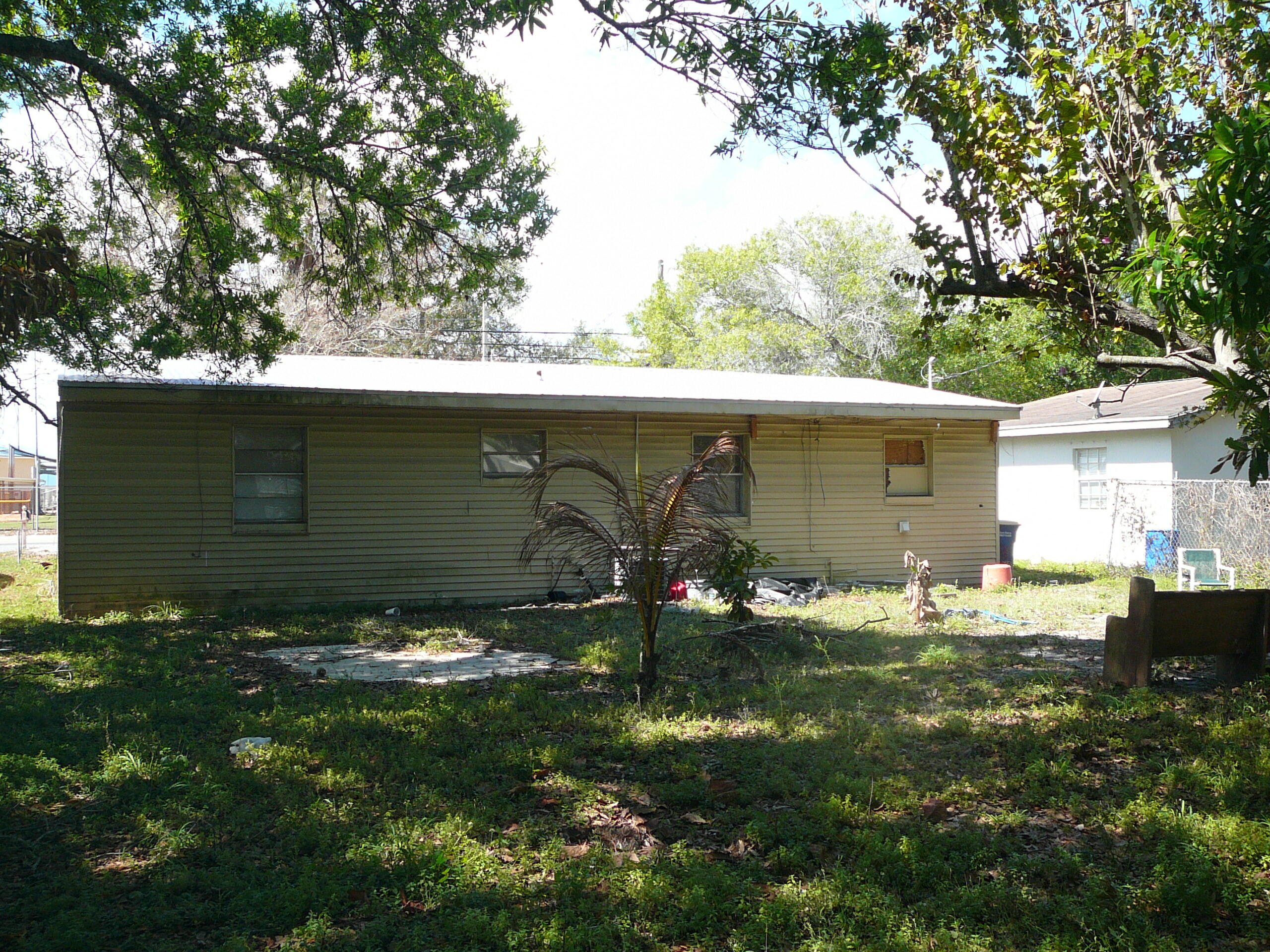 512 South 25th Street Fort Pierce, FL 34950 - Photo 4 of 17 a backyard of a house with table and chairs and barbeque