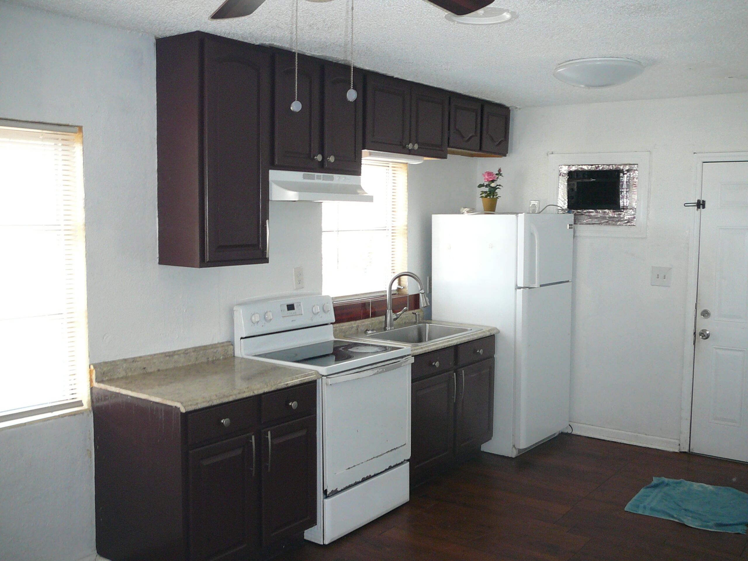512 South 25th Street Fort Pierce, FL 34950 - Photo 7 of 17 a kitchen with a sink a refrigerator and cabinets