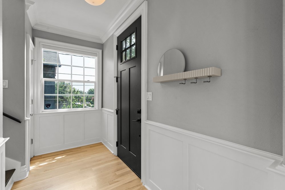 1609 Hartford Road, Unit A Austin, TX 78703 - Photo 12 of 39 A welcoming entry hall with natural light, showcasing durable hardwood flooring and crisp wainscoting.
