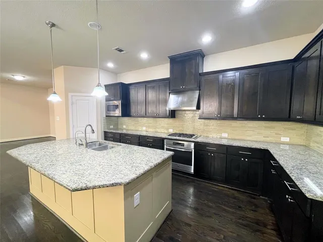 a large kitchen with stainless steel appliances granite countertop a stove and a sink