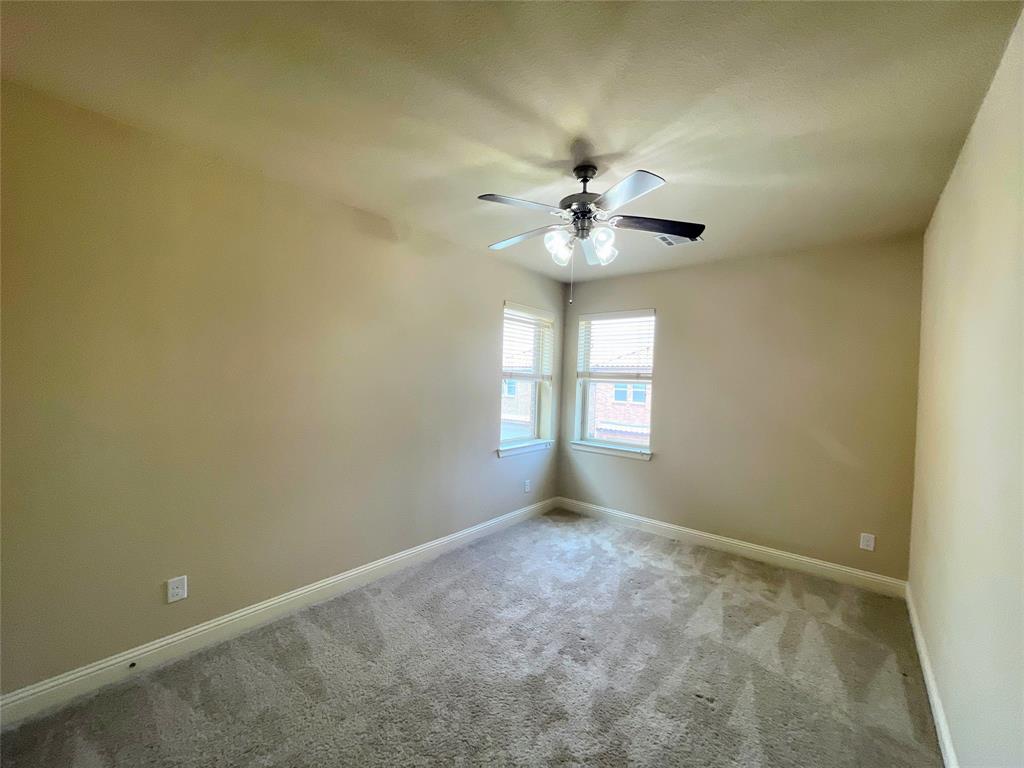 6622 DeLeon Street Irving, TX 75039 - Photo 21 of 32 an empty room with a chandelier fan and windows