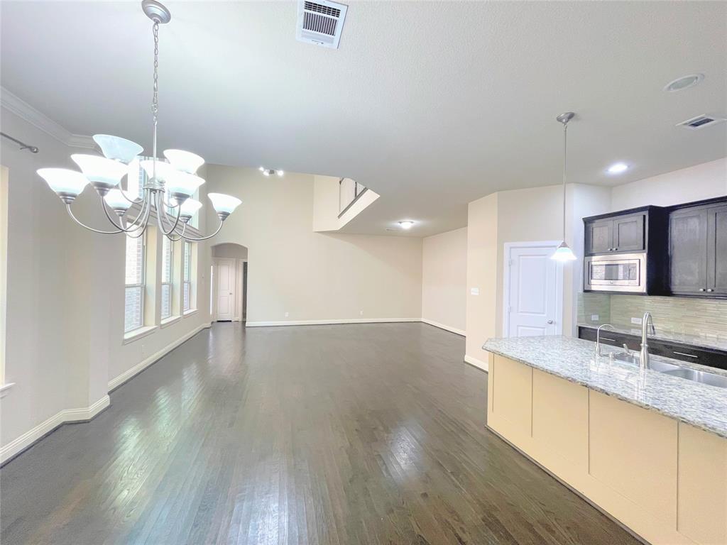 6622 DeLeon Street Irving, TX 75039 - Photo 7 of 32 a view of a kitchen with granite countertop a sink dishwasher a stove and a wooden floors