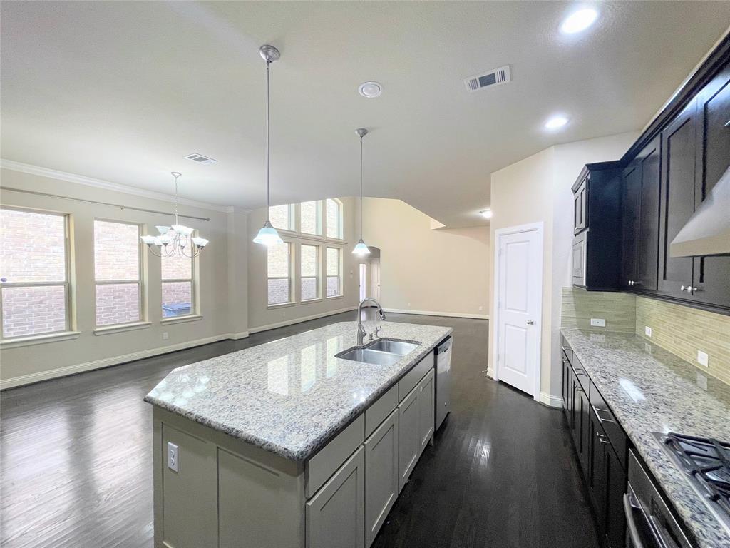 6622 DeLeon Street Irving, TX 75039 - Photo 31 of 32 a hall with kitchen island granite countertop a sink and a large window