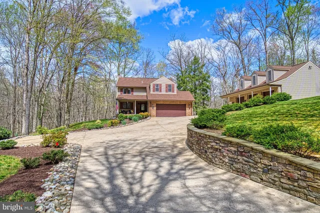 a front view of a house with a yard and tree s
