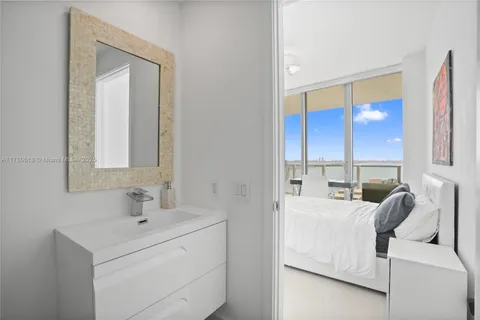 a living room with furniture floor to ceiling window and a potted plant