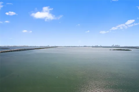 a view of a hallway with wooden floor and windows