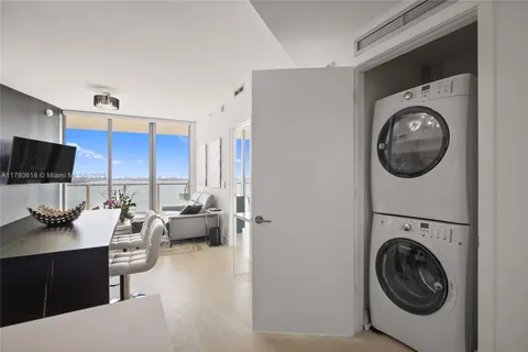 a kitchen with stainless steel appliances a sink a stove a refrigerator cabinets and living room view