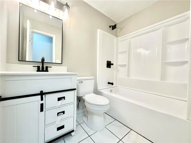 a bathroom with a sink toilet vanity and tub