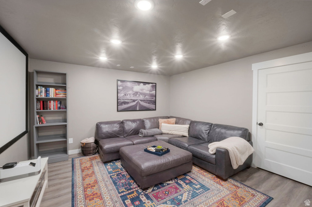 2319 North 3370 West Lehi, UT 84048 - Photo 28 of 30 Entertainment area featuring a large projector screen, recessed lighting, wood-finish flooring, and a white paneled door
