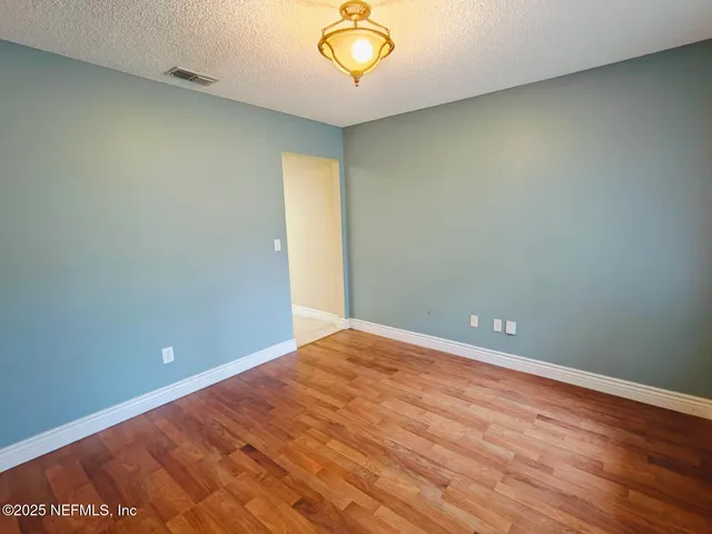 an empty room with a ceiling fan and a window