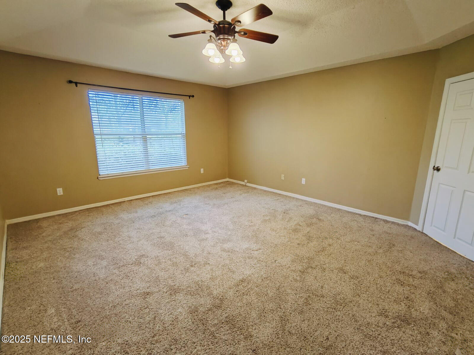 1845 Weston Circle Fleming Island, FL 32003 - Photo 17 of 36 an empty room with windows and chandelier fan