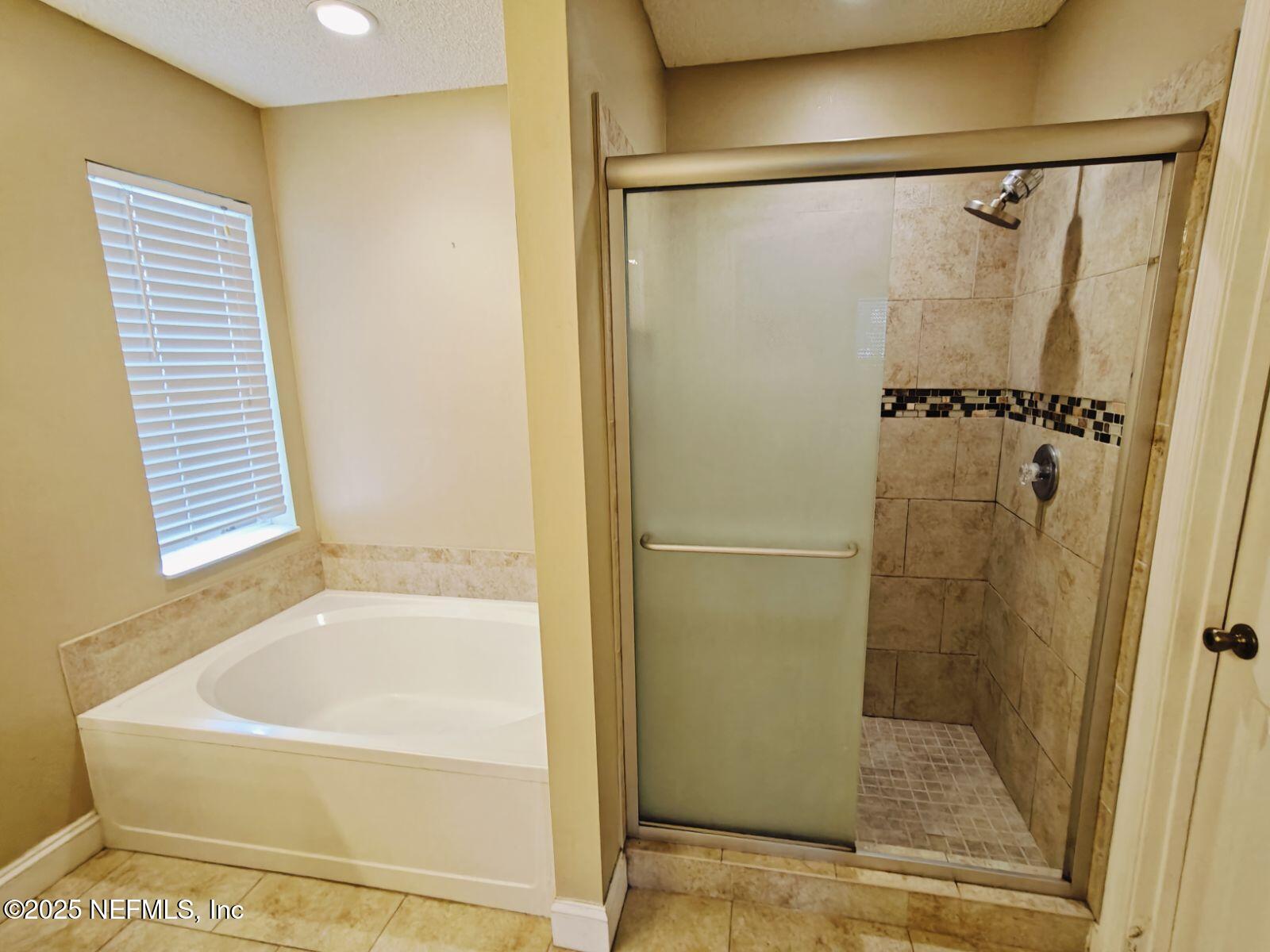 1845 Weston Circle Fleming Island, FL 32003 - Photo 19 of 36 a bathroom with a bathtub and a shower