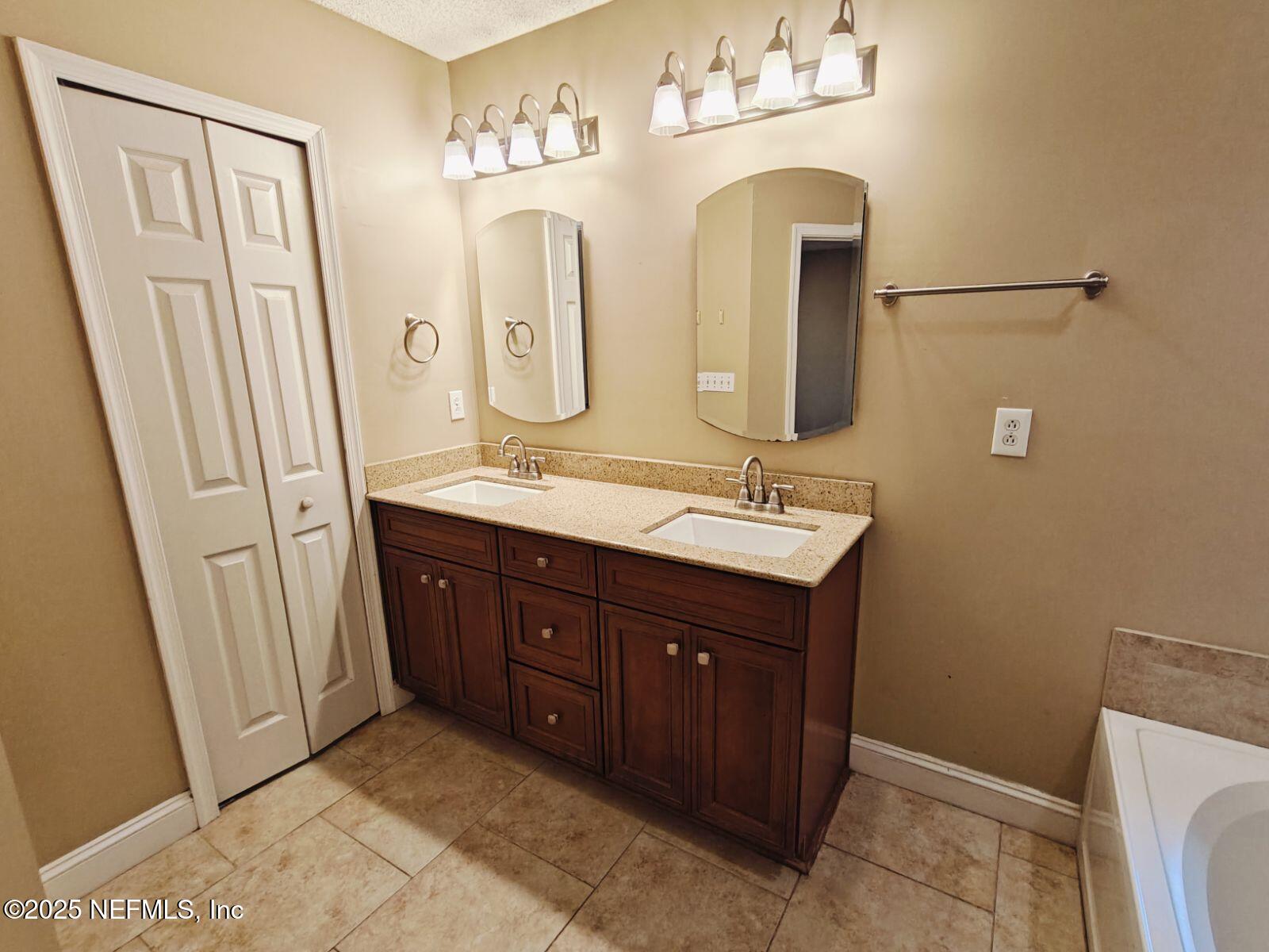 1845 Weston Circle Fleming Island, FL 32003 - Photo 20 of 36 a bathroom with double vanity sink and a mirror