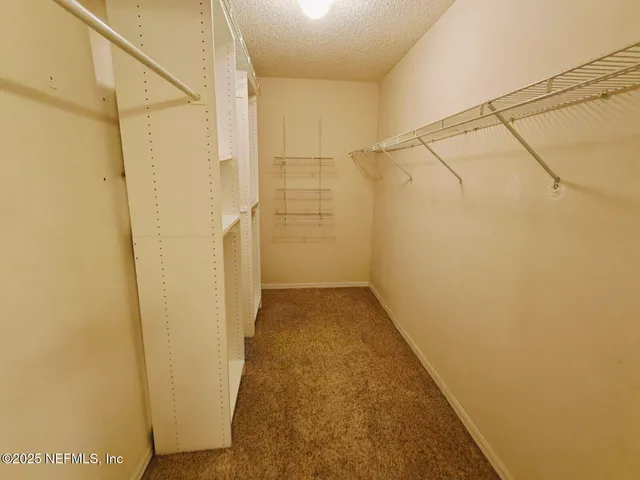 an empty room with a fan & a window