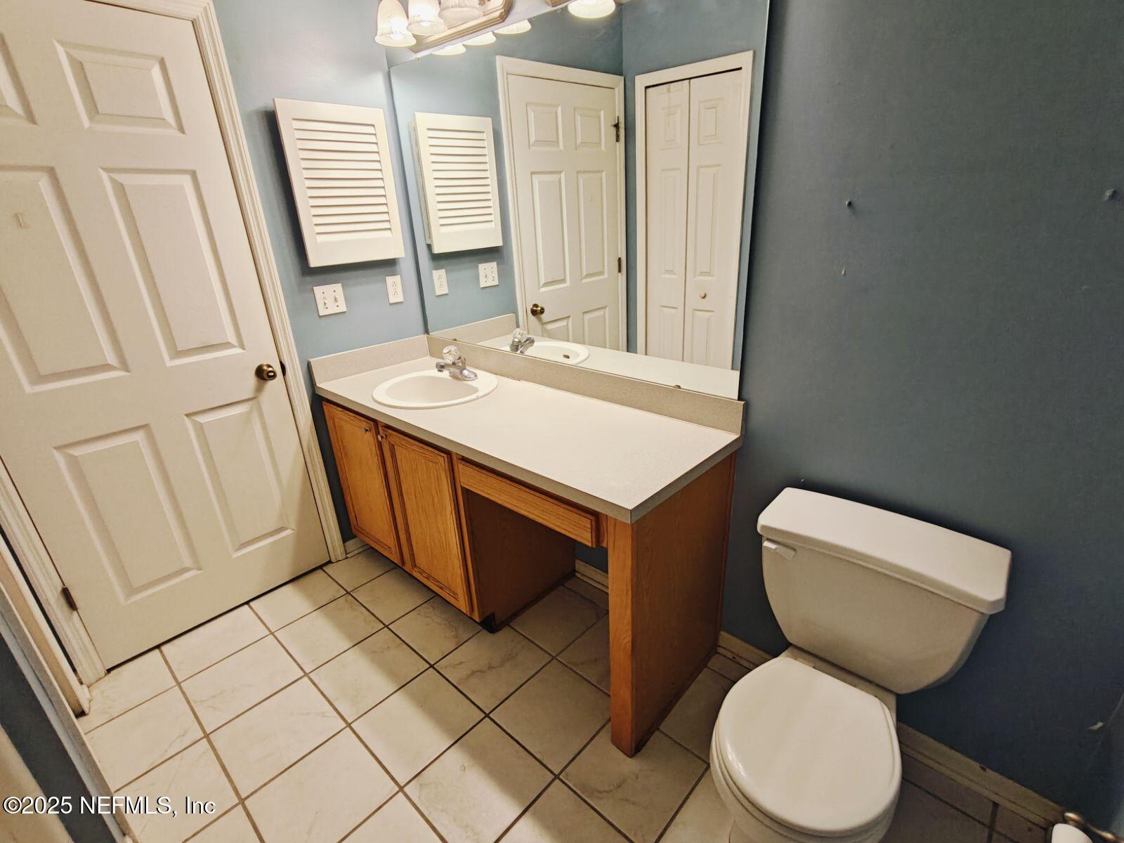 1845 Weston Circle Fleming Island, FL 32003 - Photo 29 of 36 a bathroom with a toilet a sink and a mirror