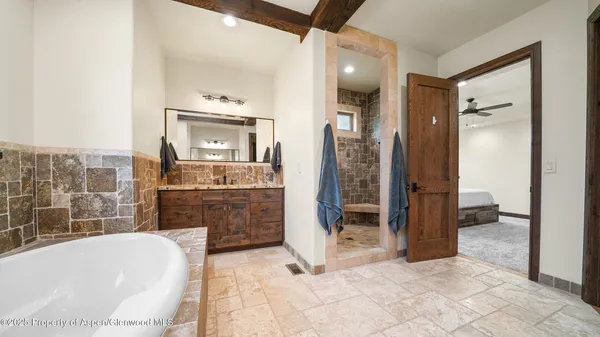 a bathroom with a tub a sink and mirrors