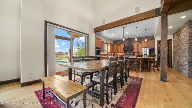 a dining hall with stainless steel appliances a dining table and chairs with wooden floor