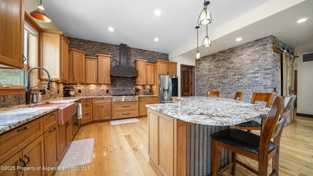a kitchen with stainless steel appliances granite countertop counter space a sink refrigerator and cabinets